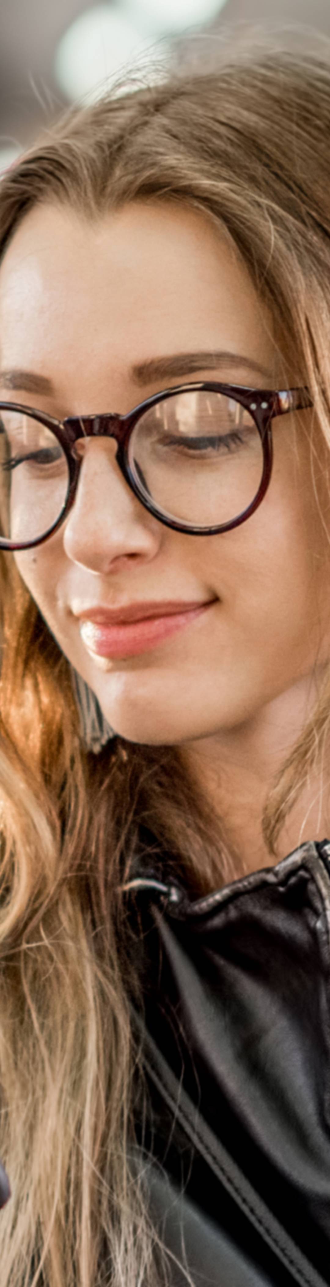 Ung kvinne som sitter og ser på mobilen