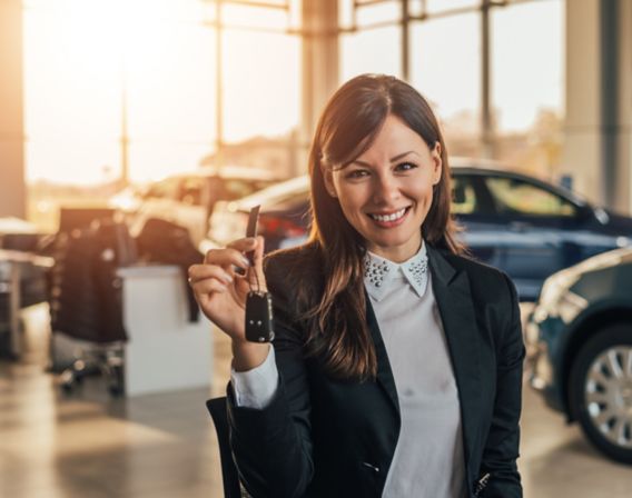 Image of a smiling woman who is going to test drive a car