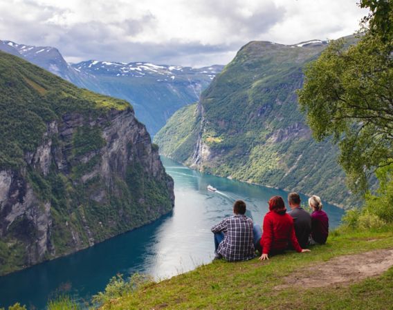 People looking across a fjord and mountains 