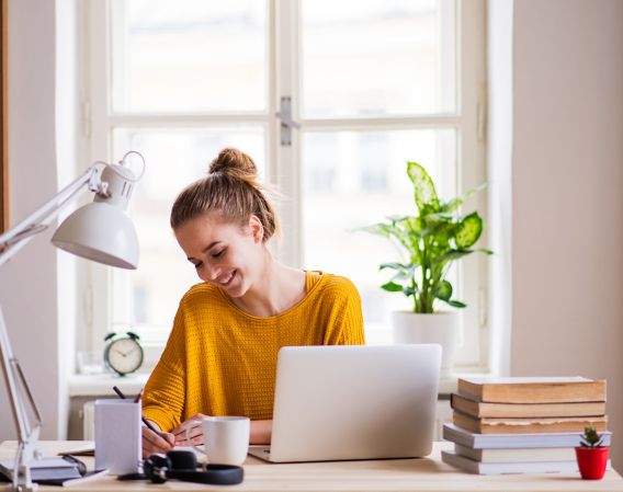 Image of a smiling woman working in her home office