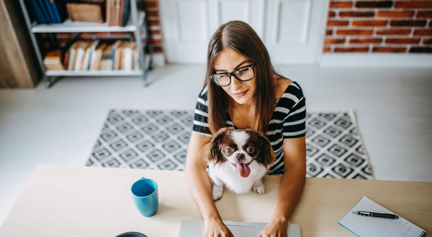 Woman in home office with a dog.