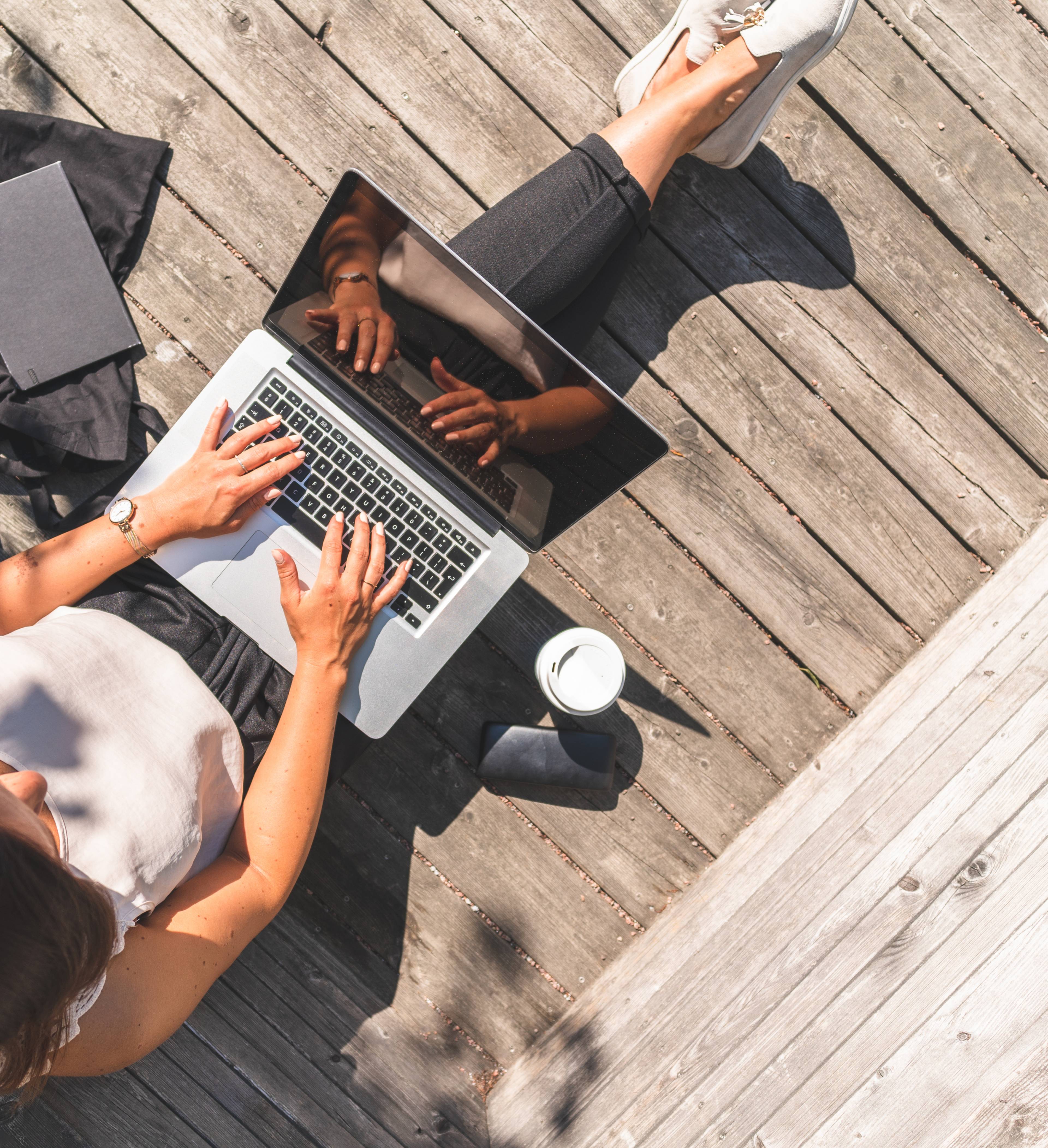 Woman with laptop working on the veranda