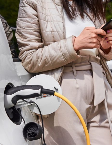 Image of a woman charging an electric vehicle