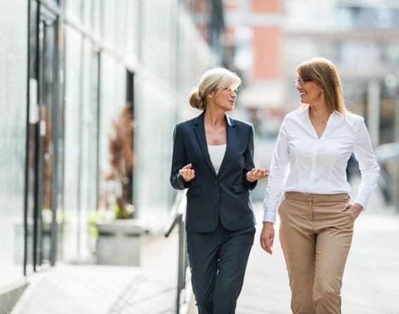 Two women walking along the road and talking