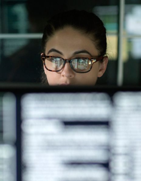 Image of woman with glasses in front of a computer
