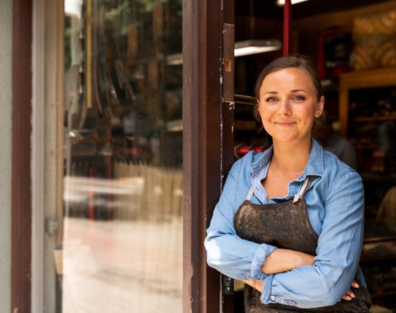 Kvinne som smiler i døråpningen på en butikk