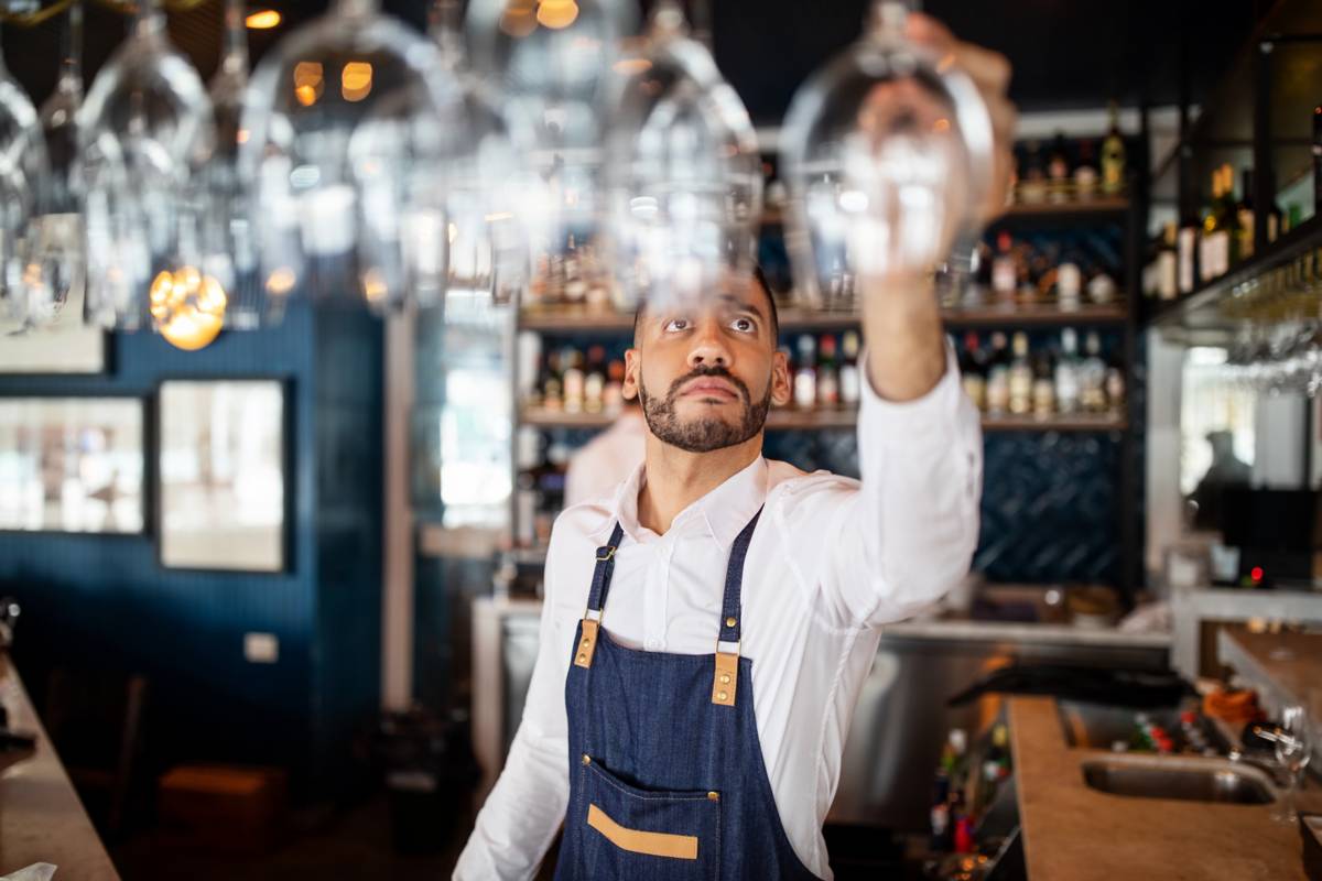 Bartender hanging up a glass