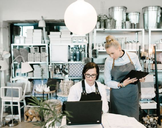 Image of two female colleagues looking at a computer in a shop
