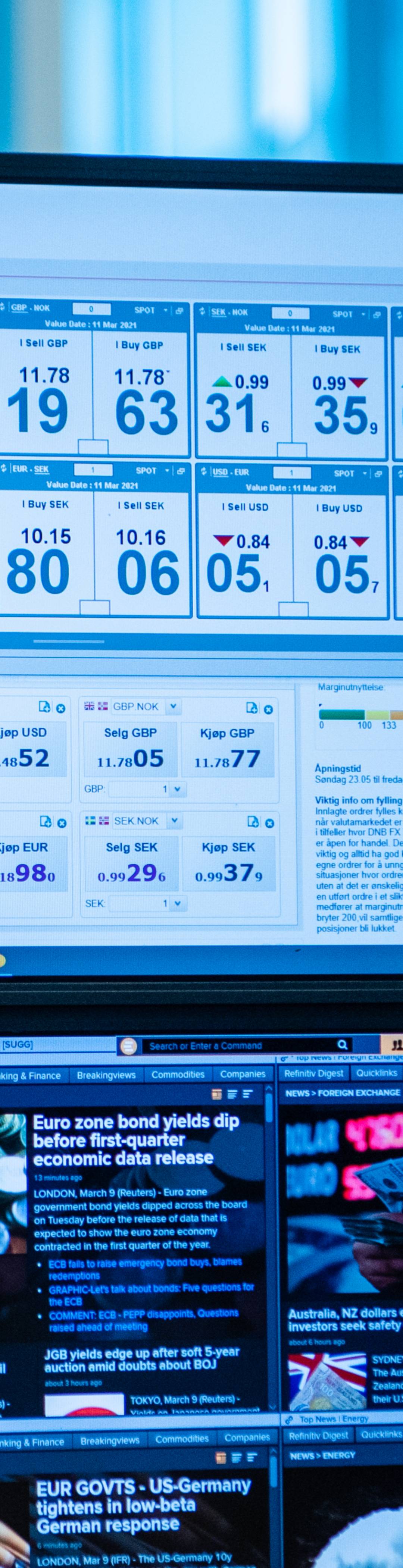 Ung kvinne sitter foran en skjerm og ser på valutakurser