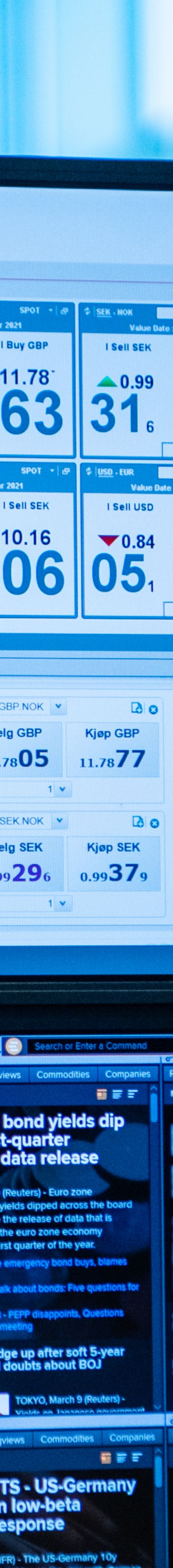 Young woman sitting in front of a screen looking at foreign exchange rates