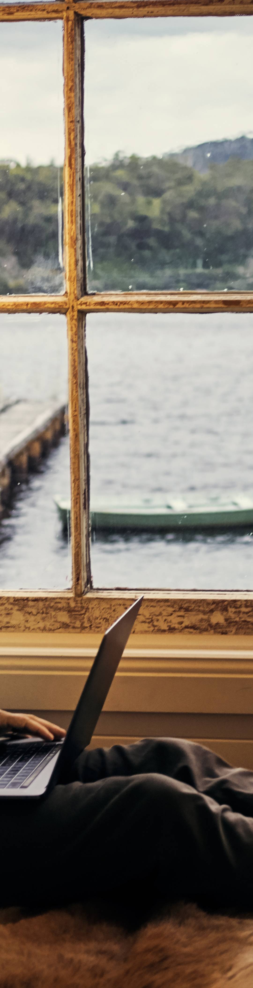 Mann med PC på sjøhytte