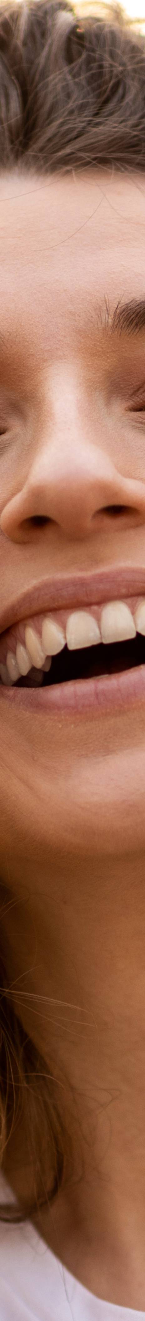 Ung dame med krøllete hår som smiler over best i test-forsikring.