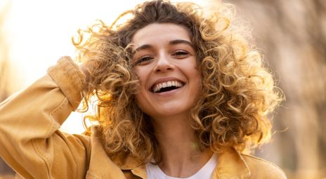 Young woman with curly hair who is smiling about best in test insurance.