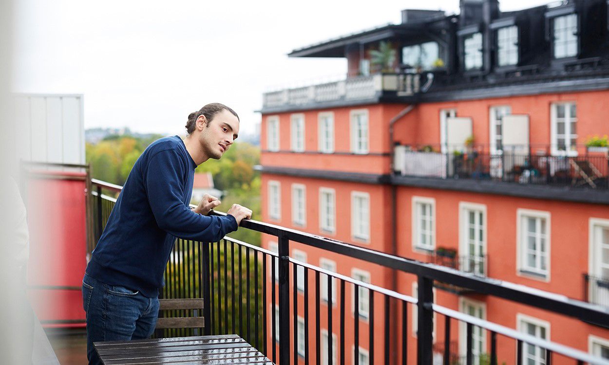 Ung mann på balkong