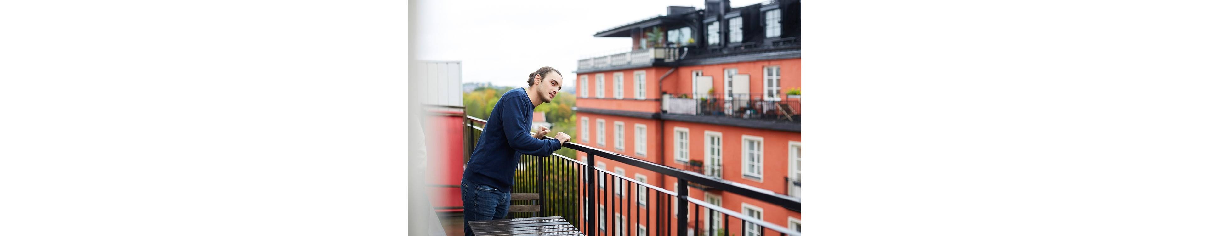 Ung mann på balkong