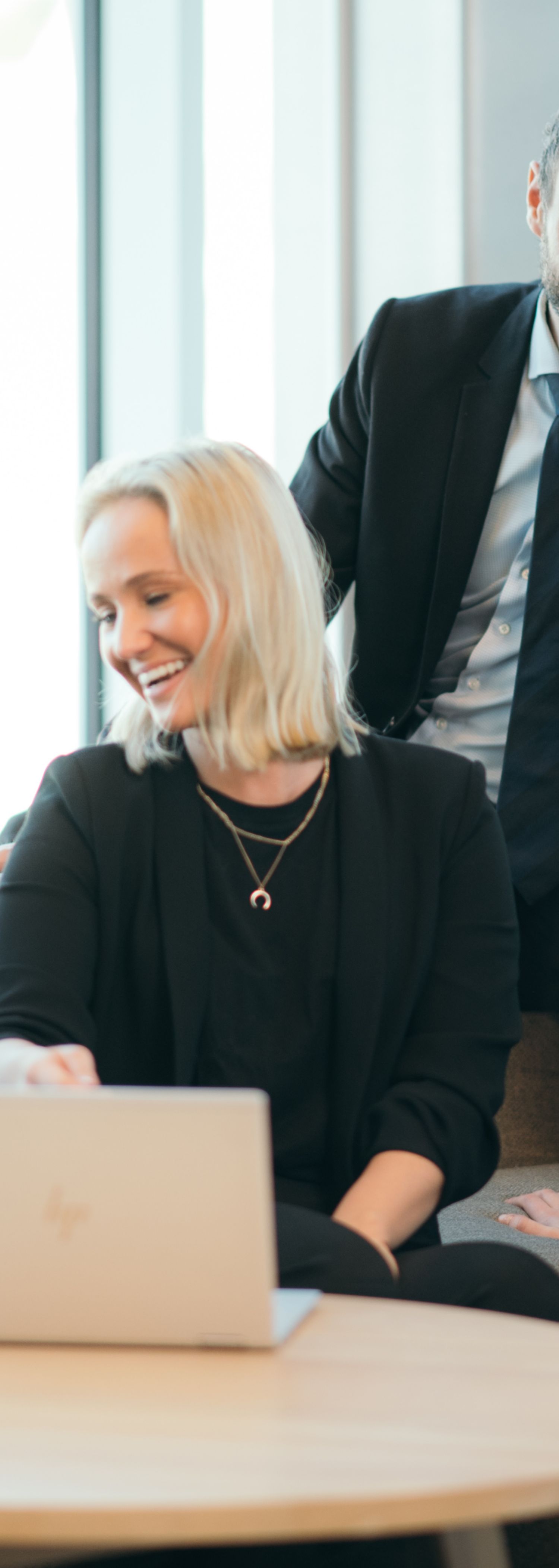 A number of people from consulting sitting together on a sofa laughing 