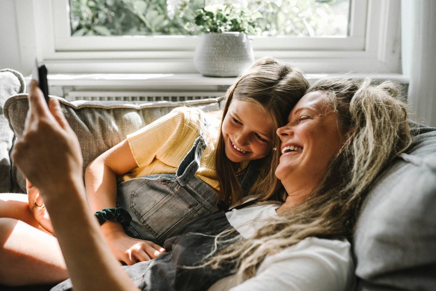Mother and daughter using tablet in living room