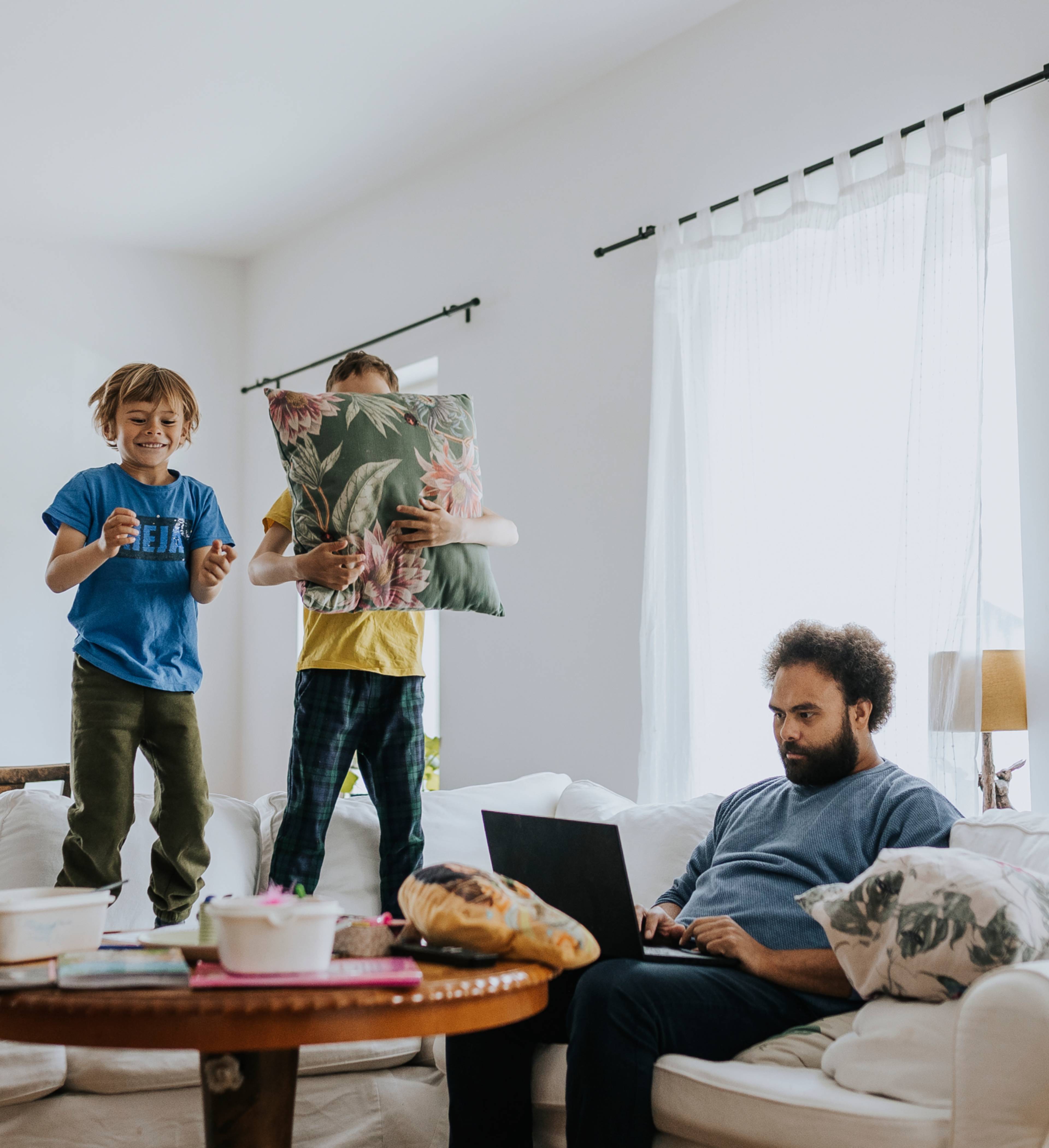 Barn som hopper i sofaen når pappa arbeider