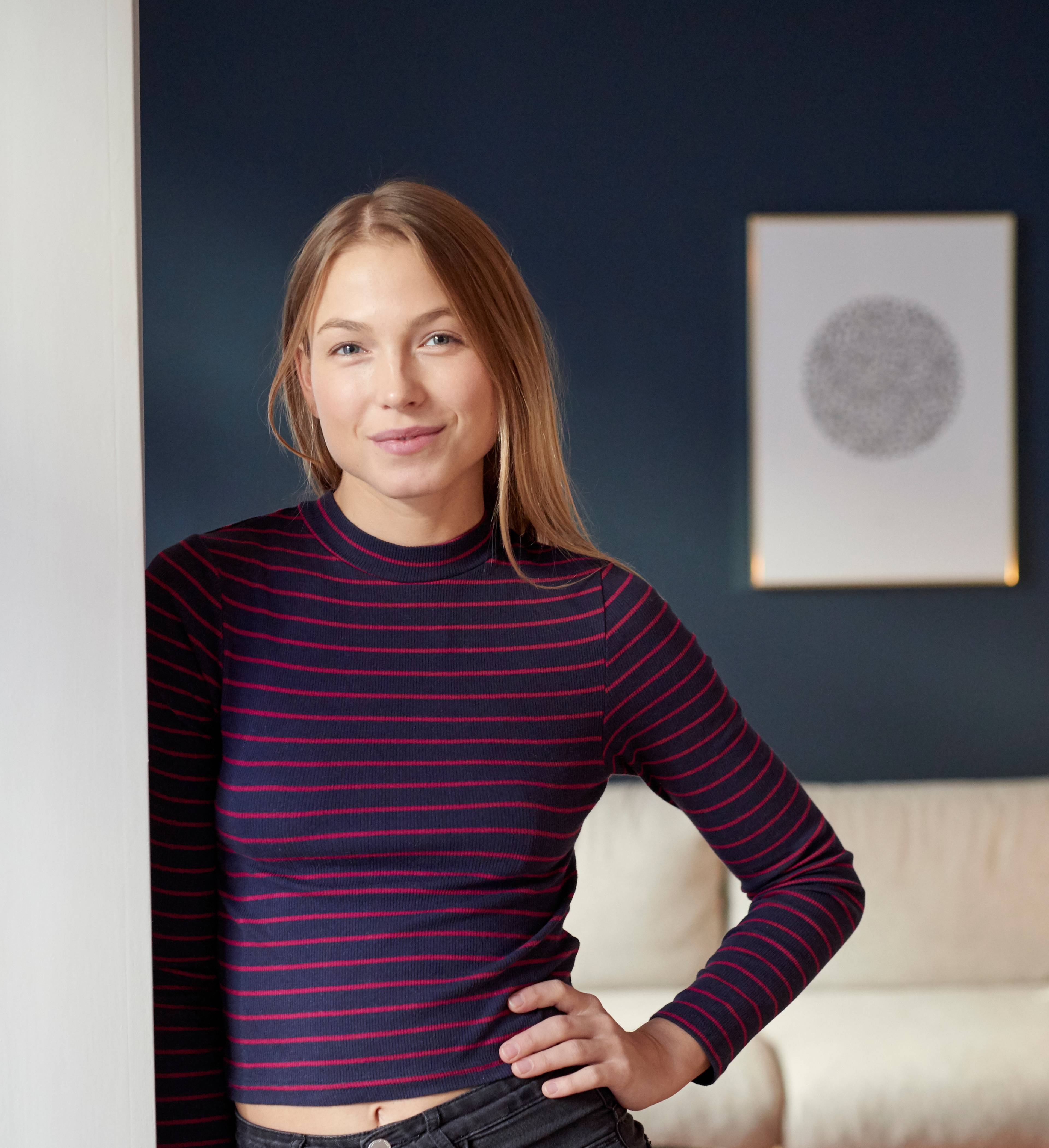 Ung kvinne står i stuen