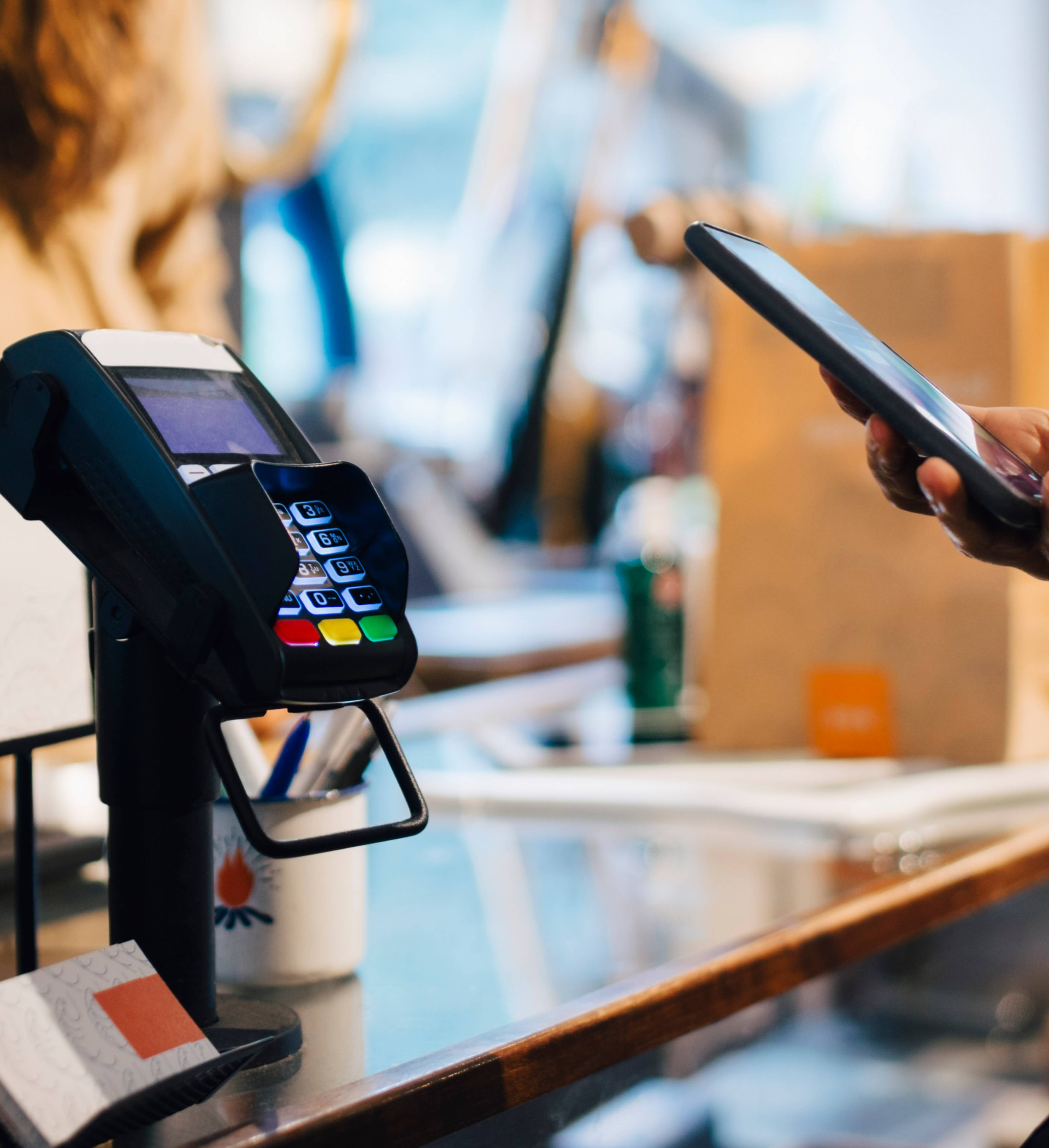 Person betaler med mobil på terminal