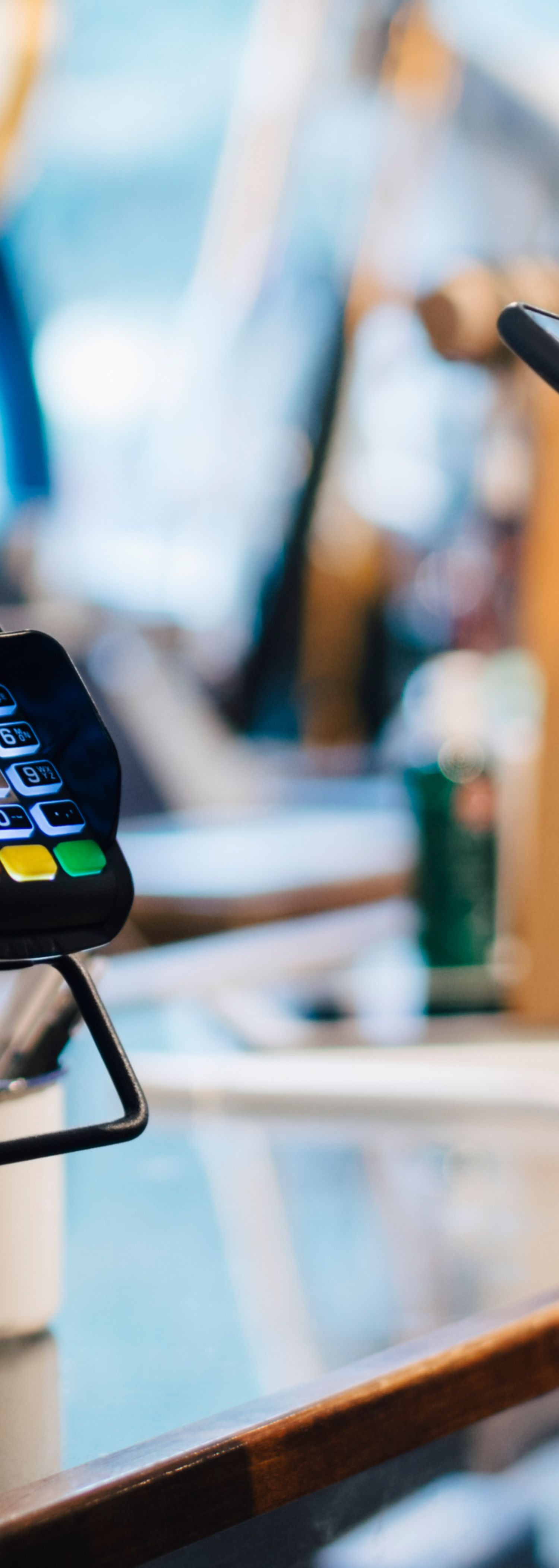 Person betaler med mobil på terminal