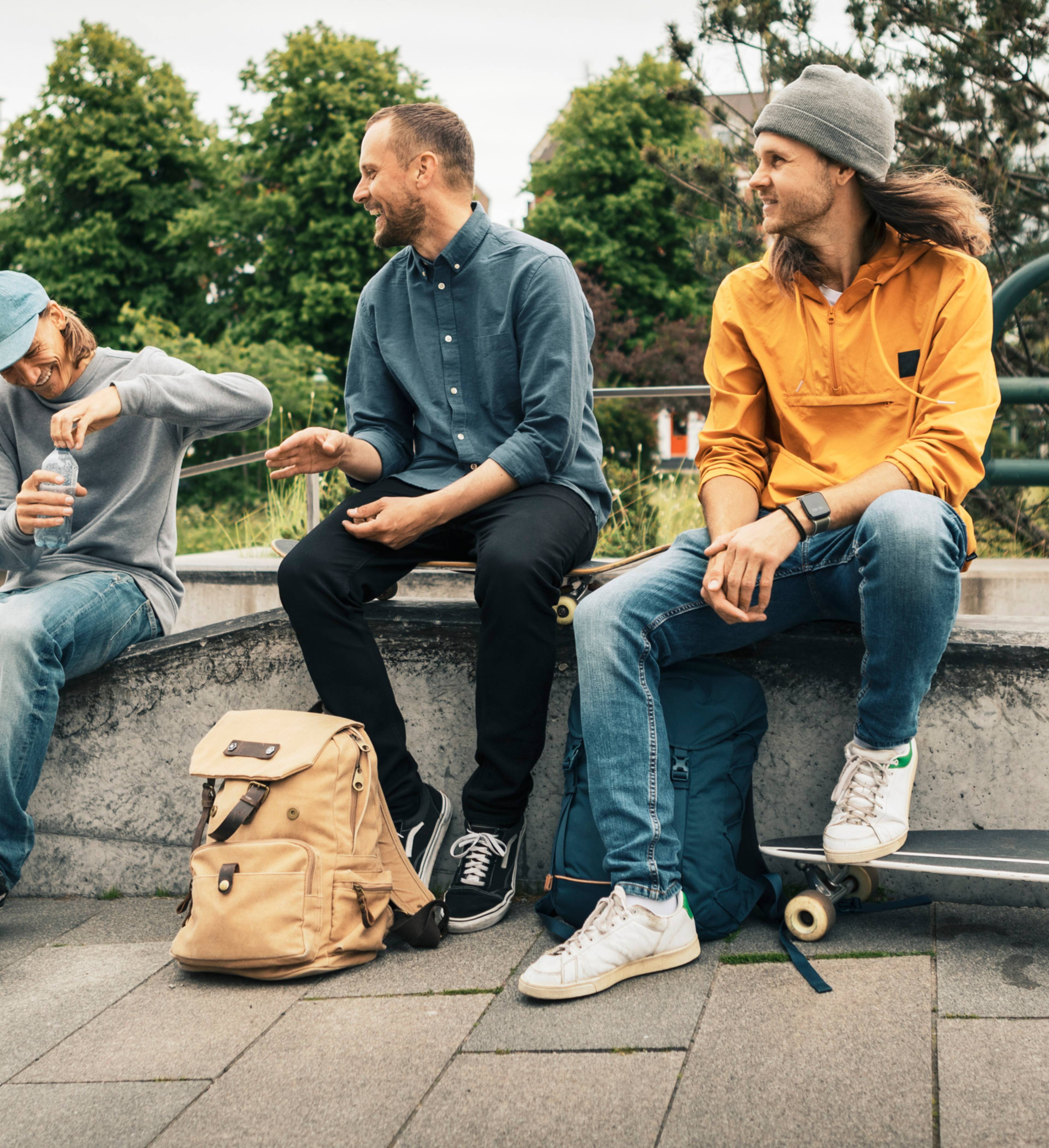 Venner sitter sammen i skatepark