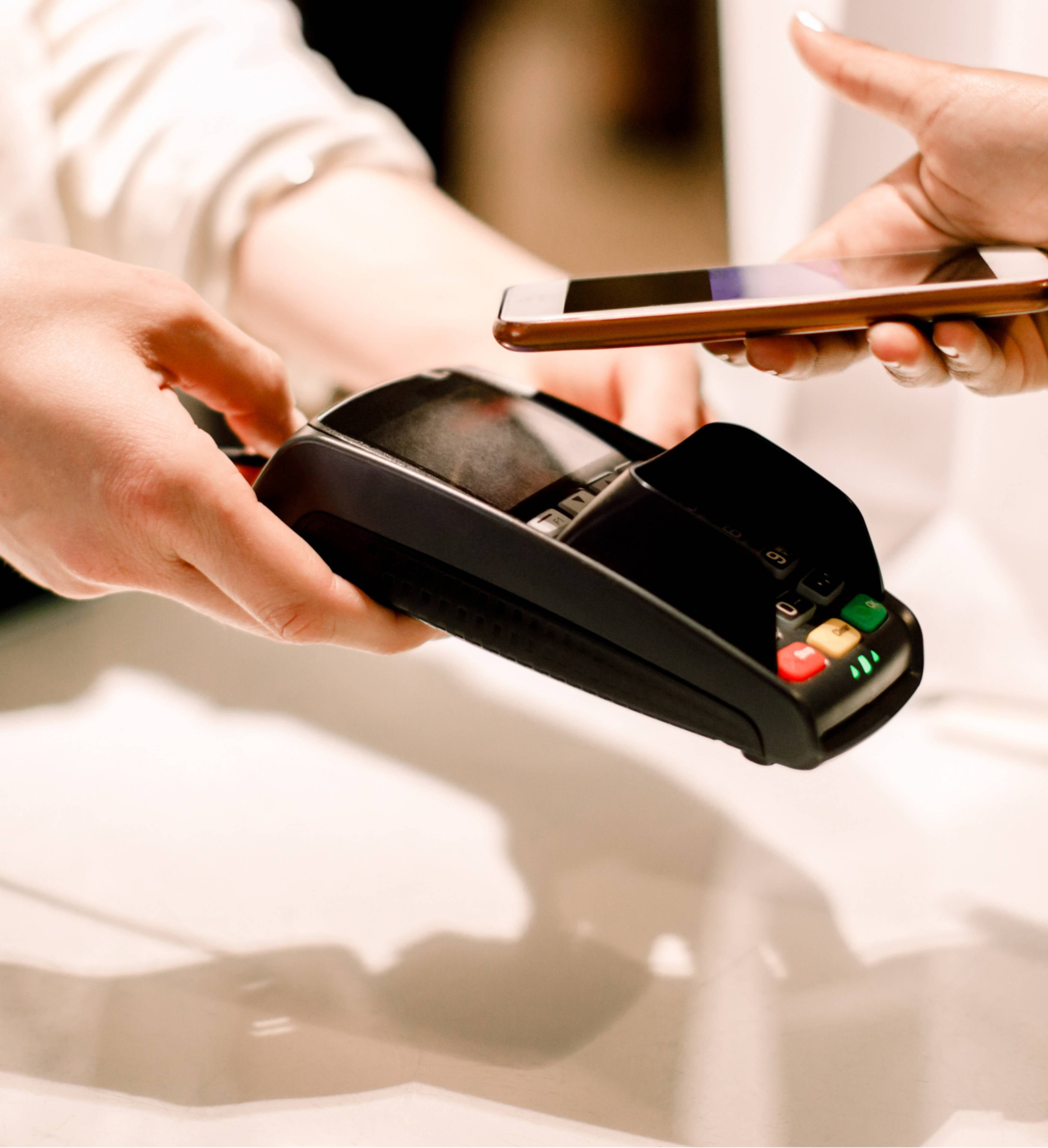 Person betaler med mobil i butikk