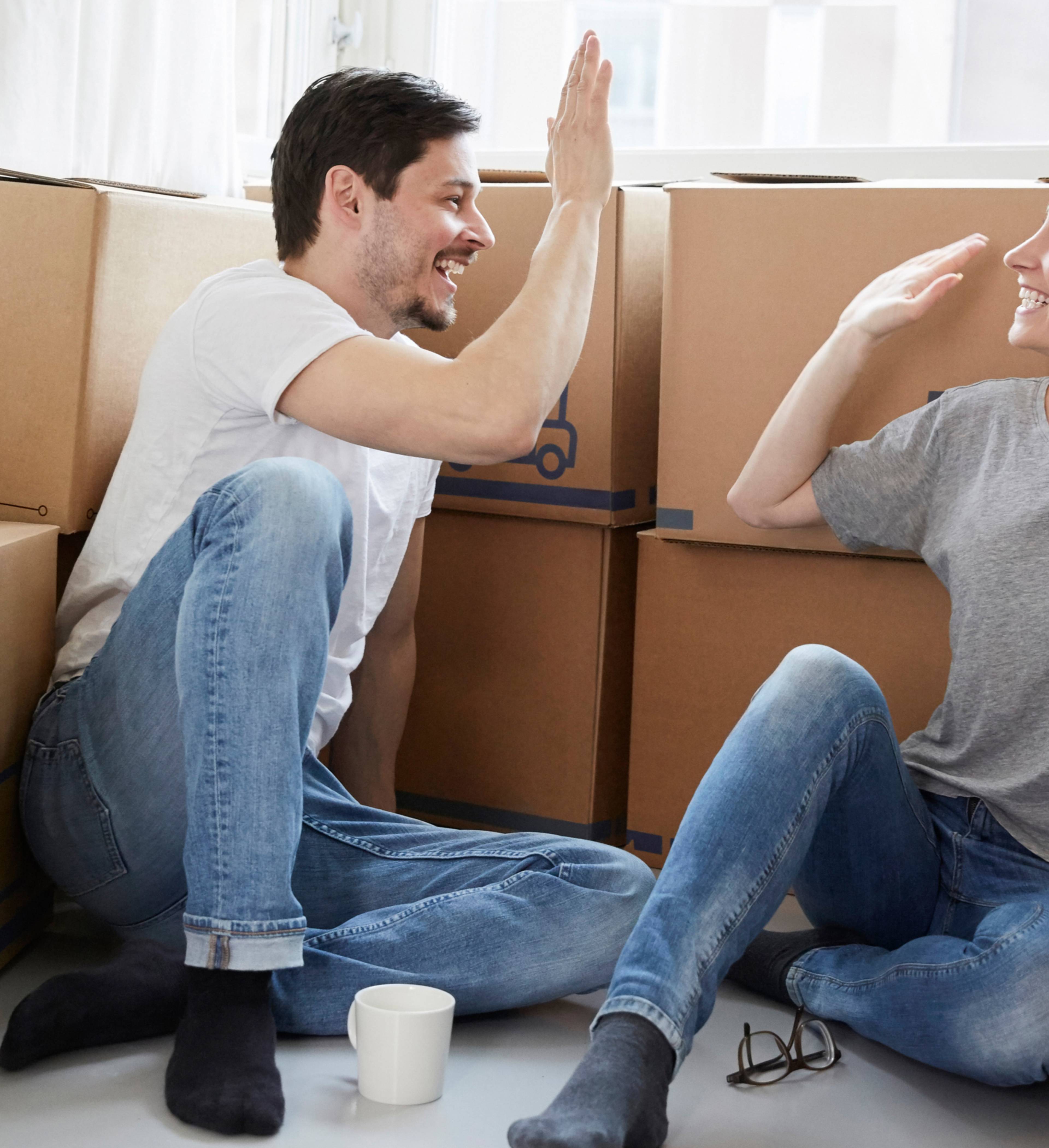 Par sitter med flytteesker og tar high-five