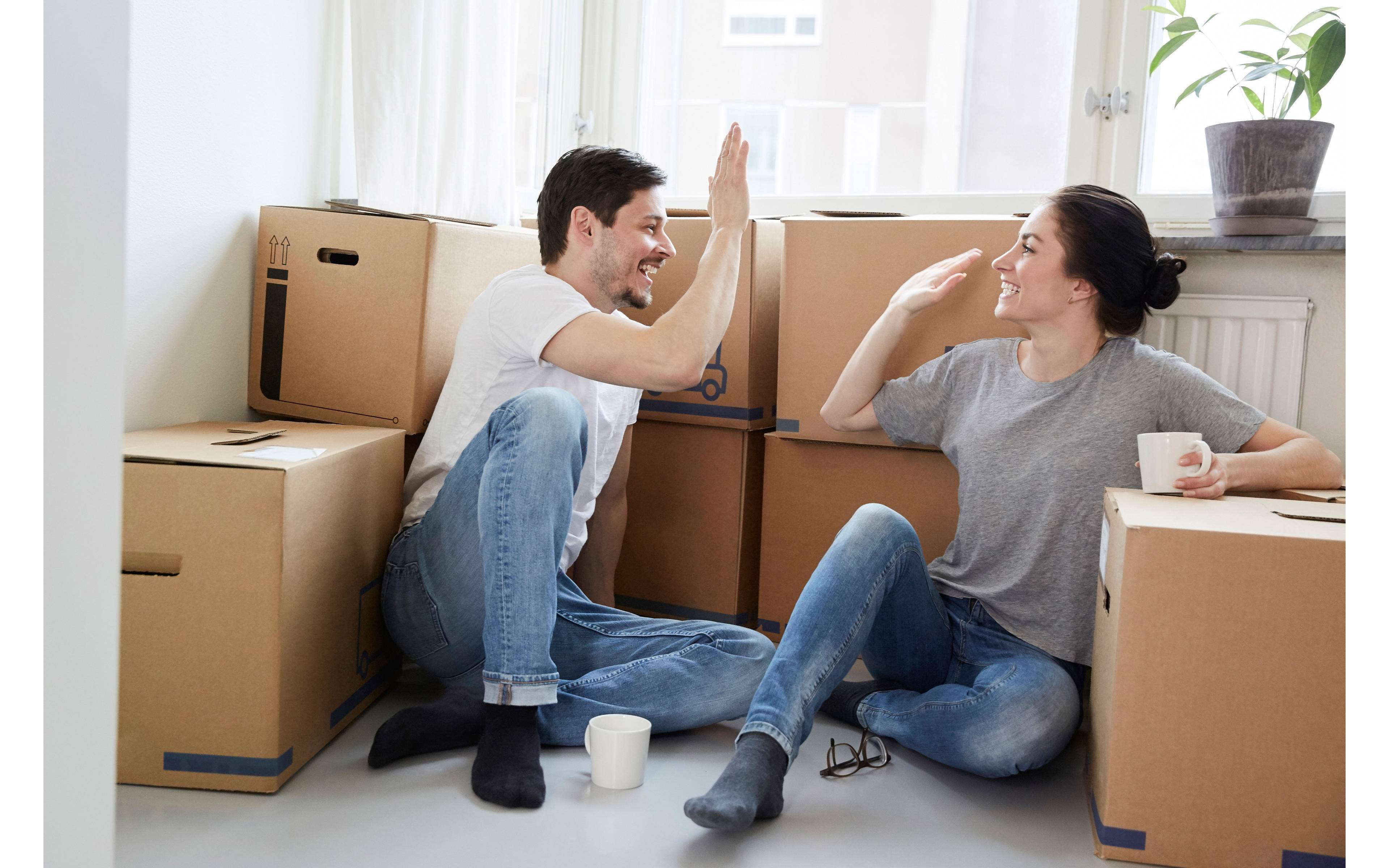 Par sitter med flytteesker og tar high-five