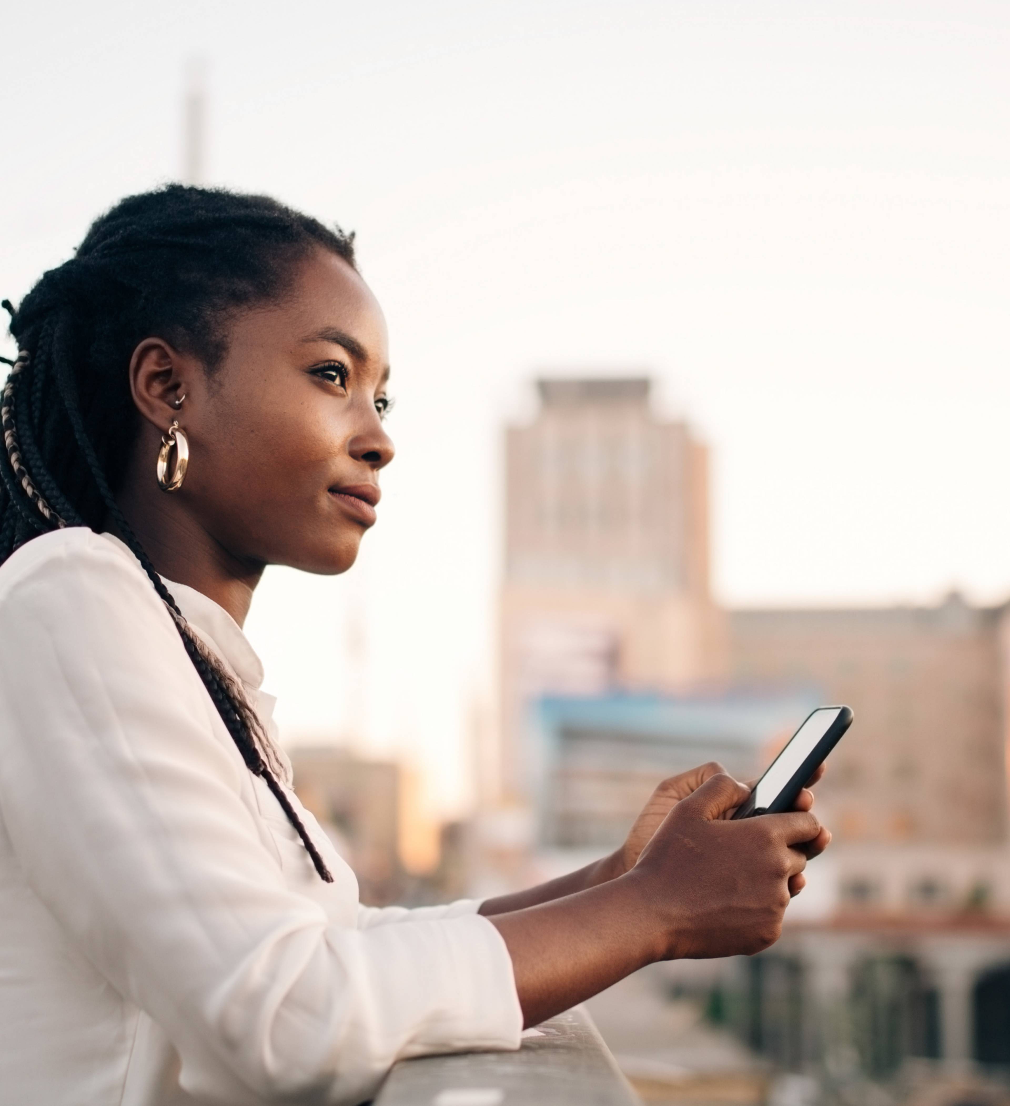 Kvinne ser utover by fra bro