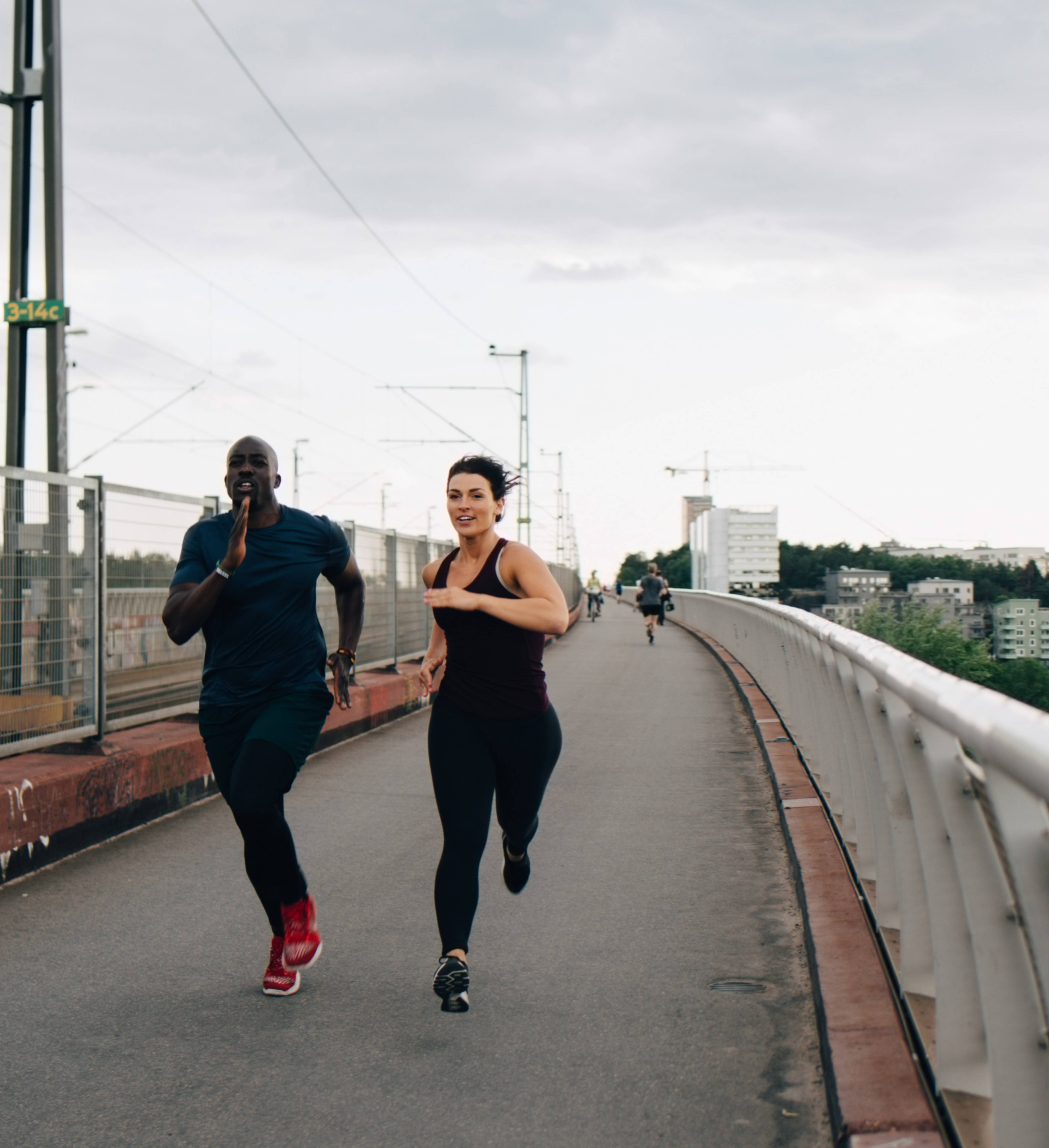 Mann og kvinne løper om kapp over bro