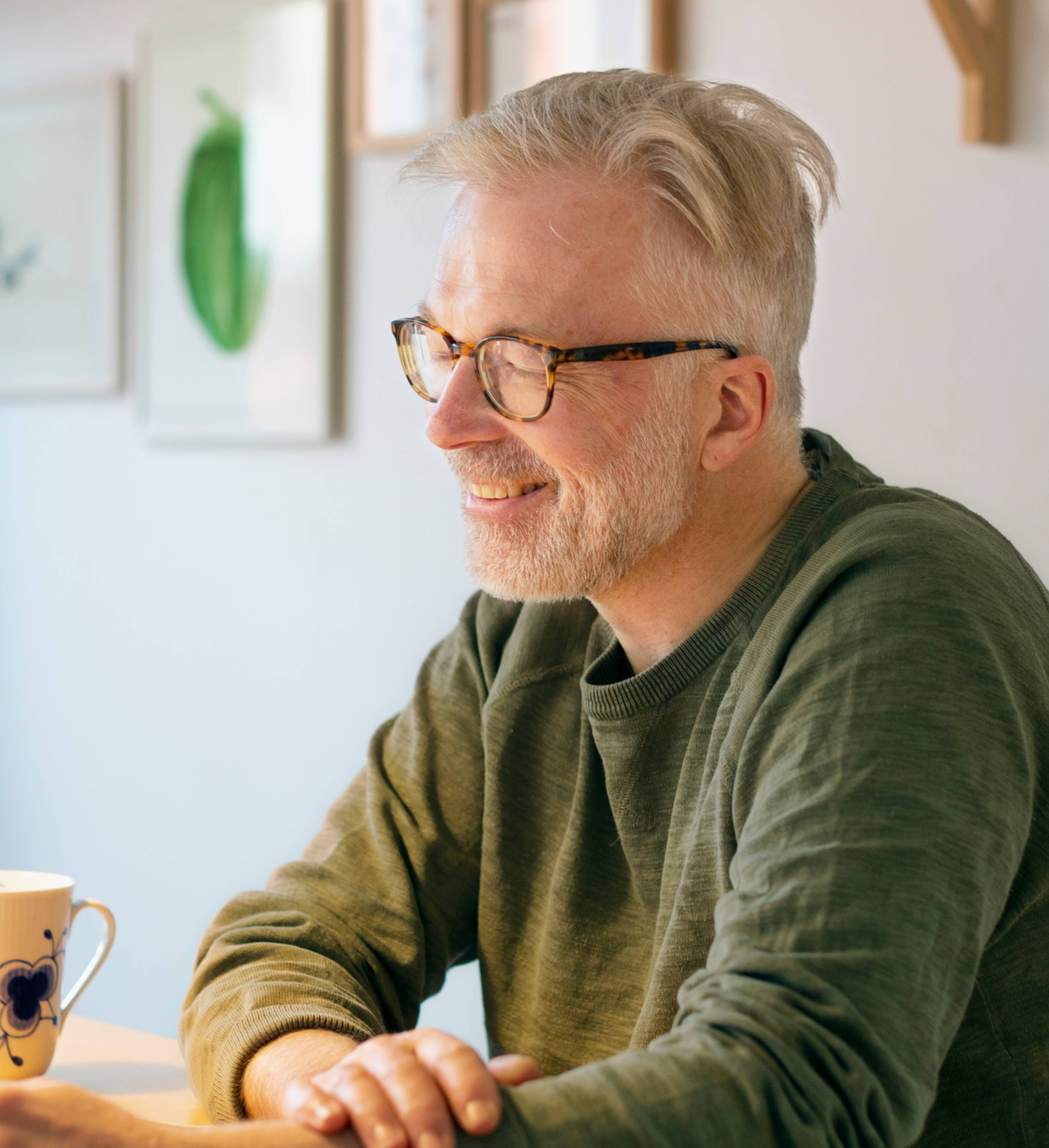 Mann sitter ved spisebordet med nettbrett