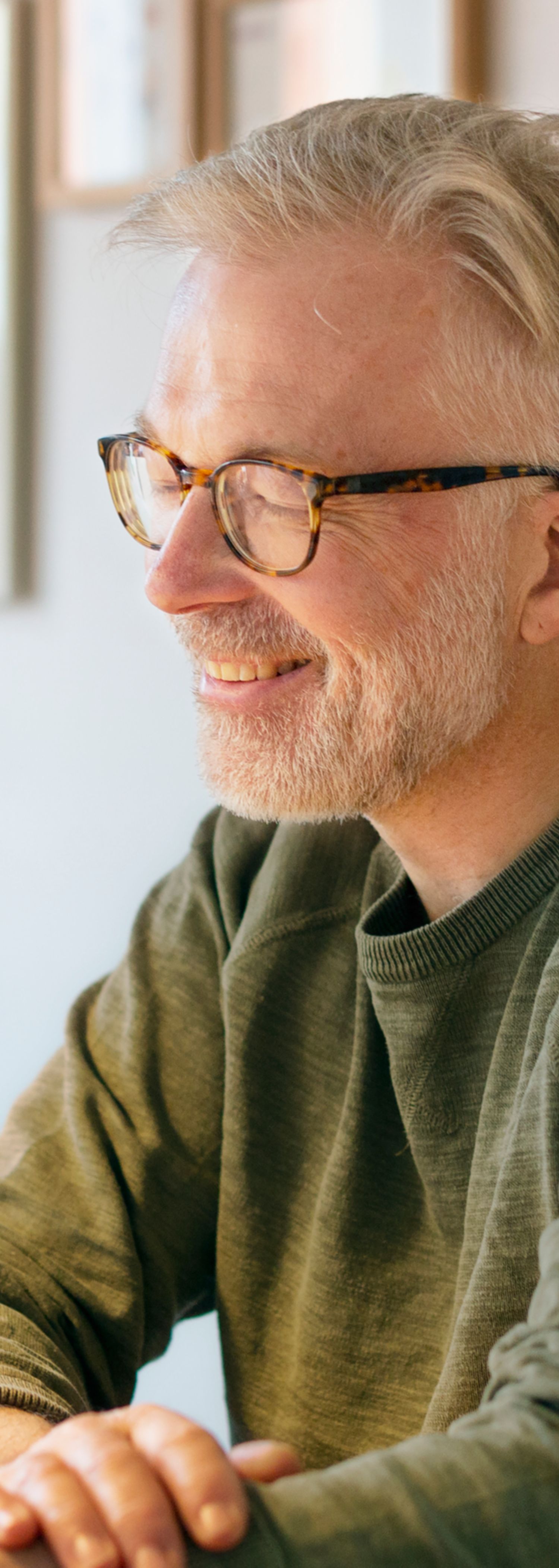 Mann sitter ved spisebordet med nettbrett