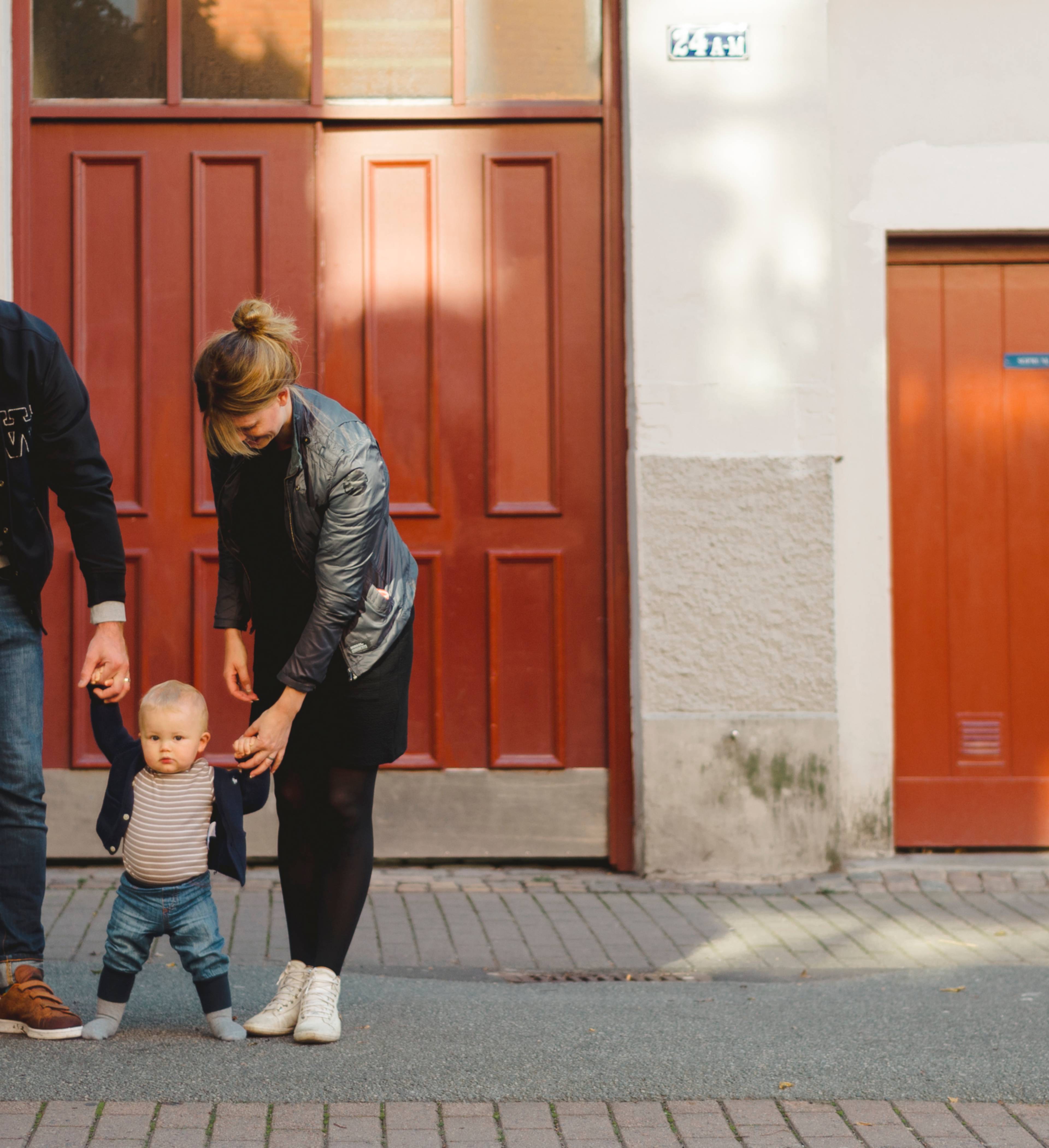 Familie med baby utenfor bygg