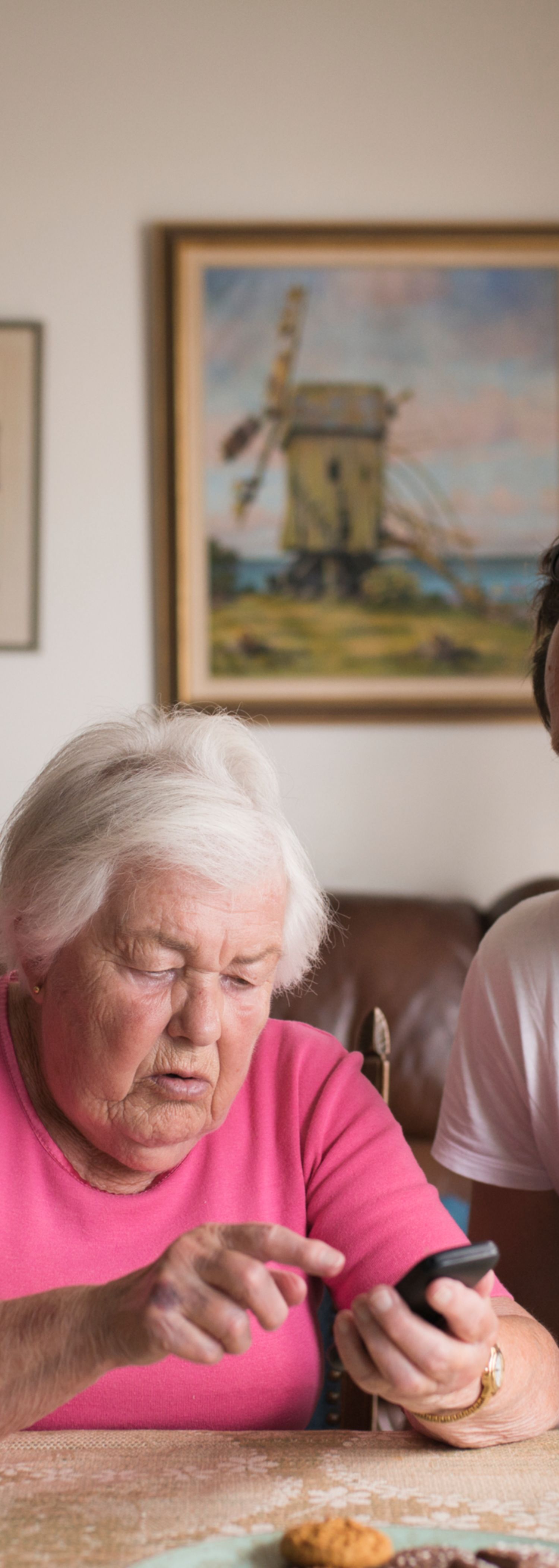 Familie hjelper gammel dame med telefonen