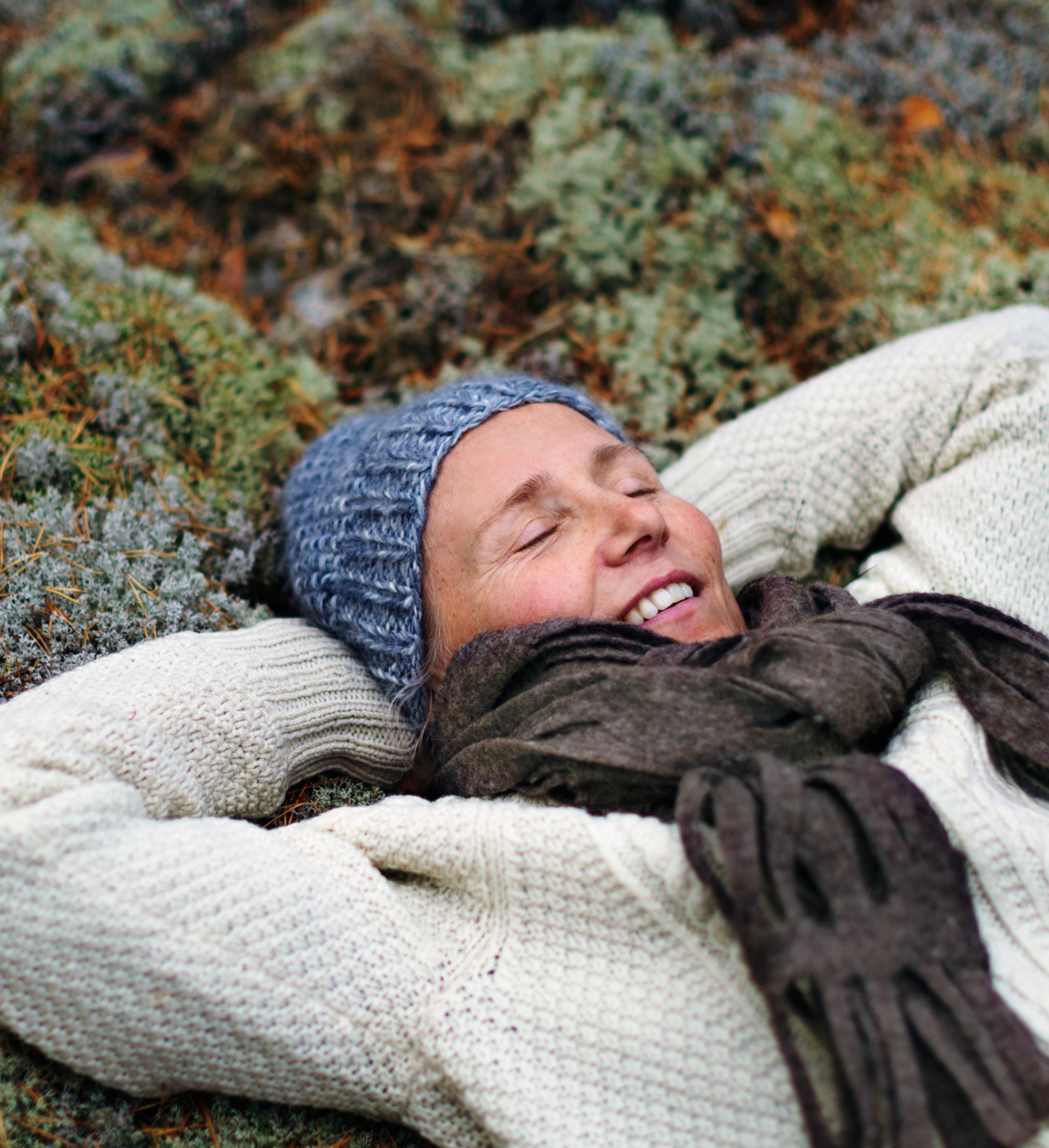 Glad kvinne hviler i lyngen