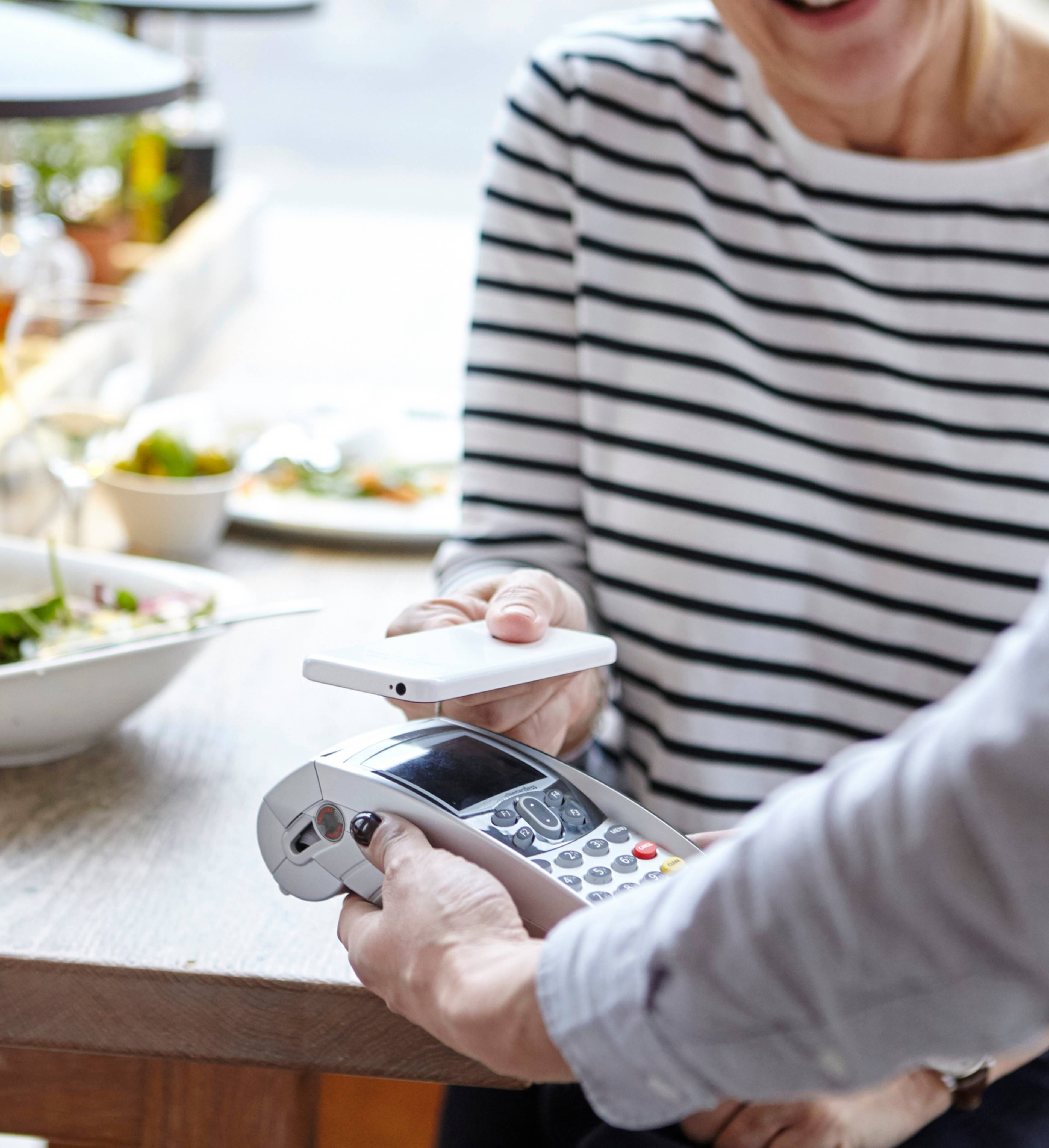 Kvinne betaler med mobiltelefon