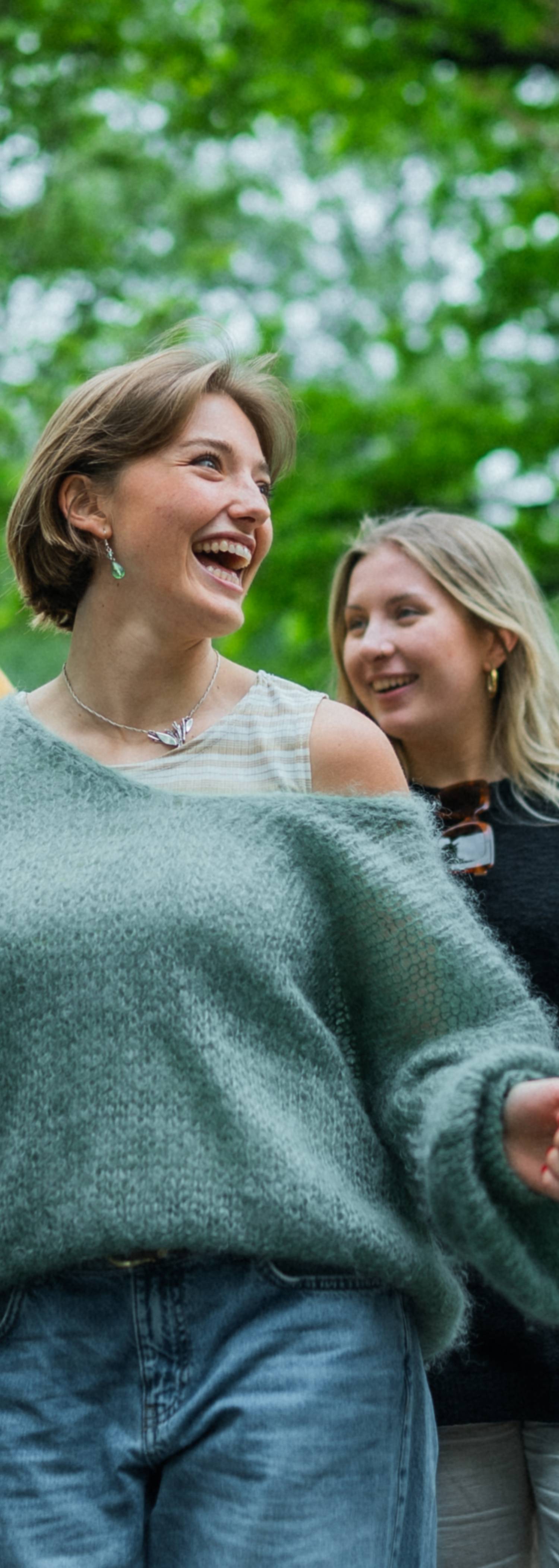 En vennegjeng som smiler og ler i parken