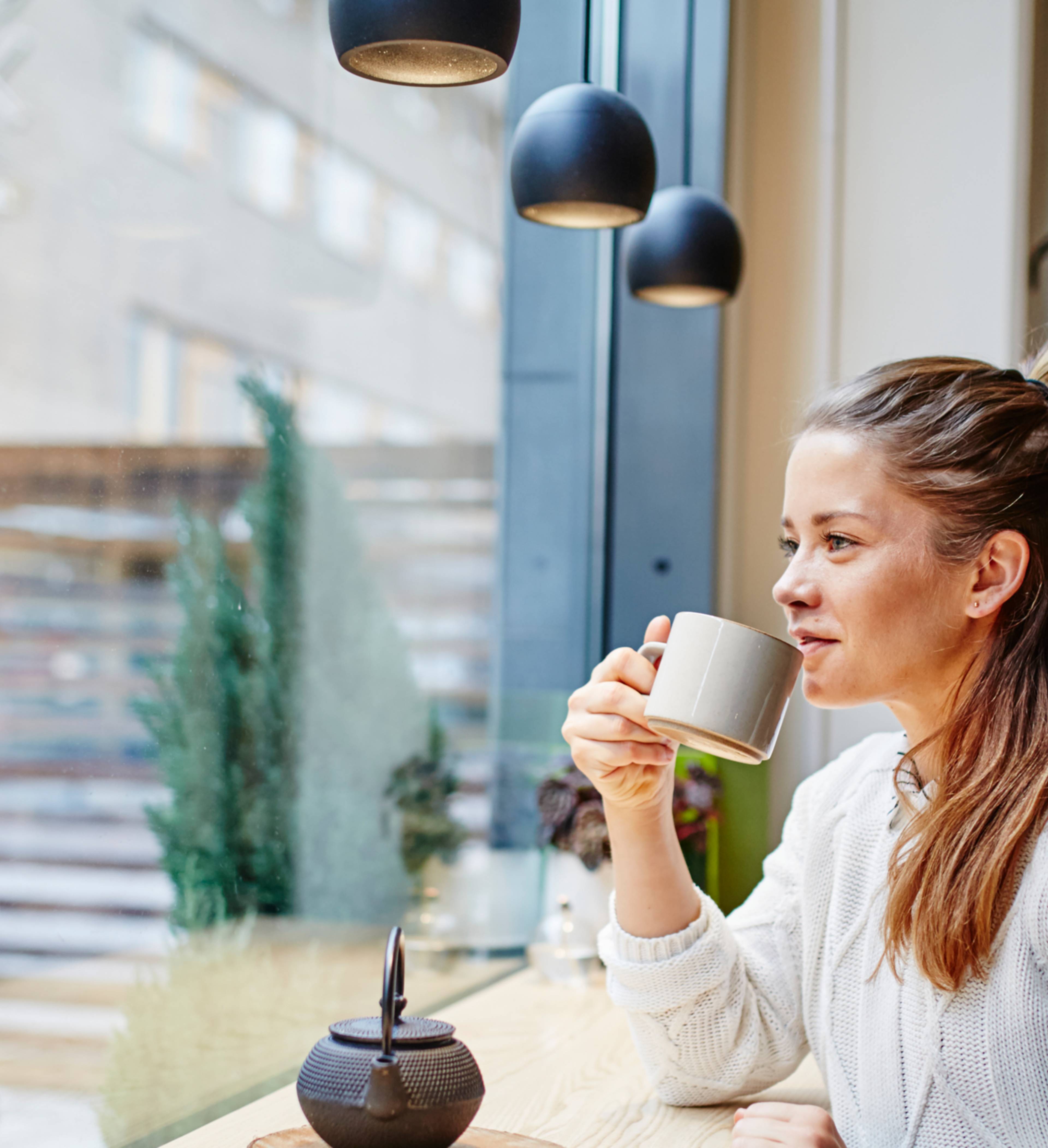 Ung kvinne drikker te pa? cafe PRISER