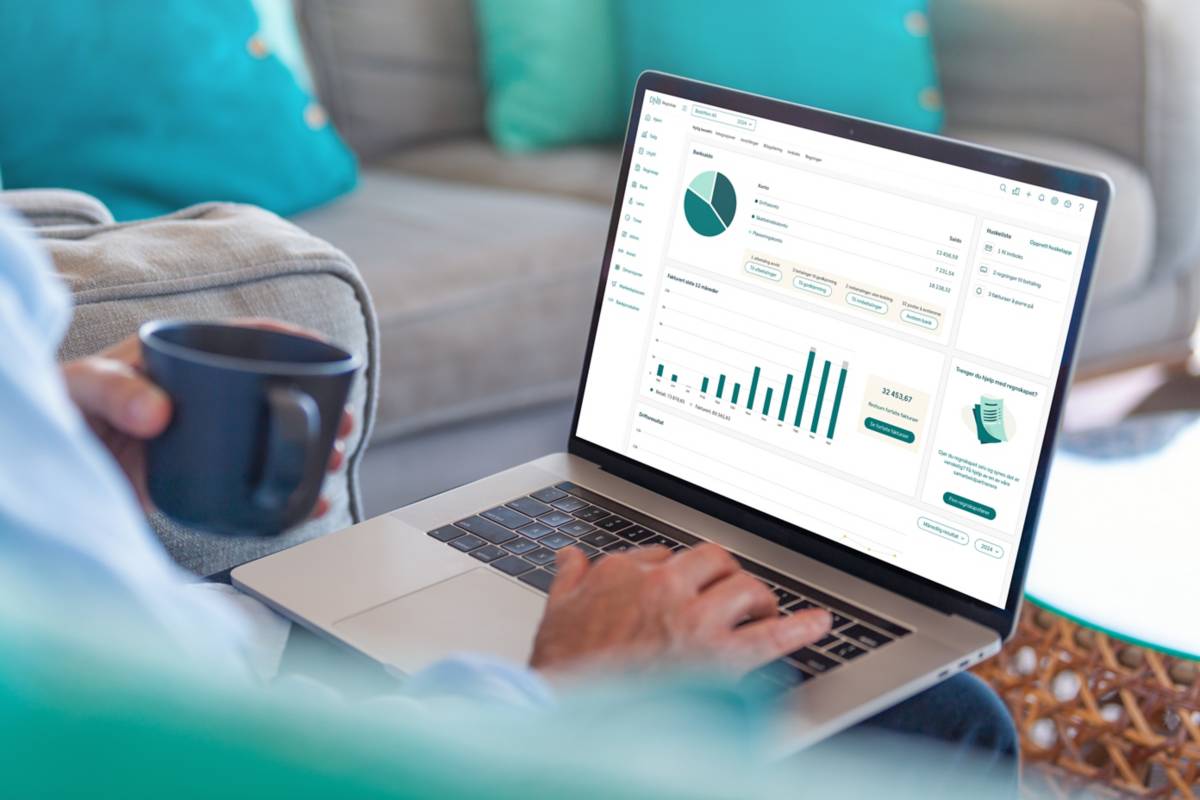 A person sitting and typing on a computer with the accounting app DNB Regnskap