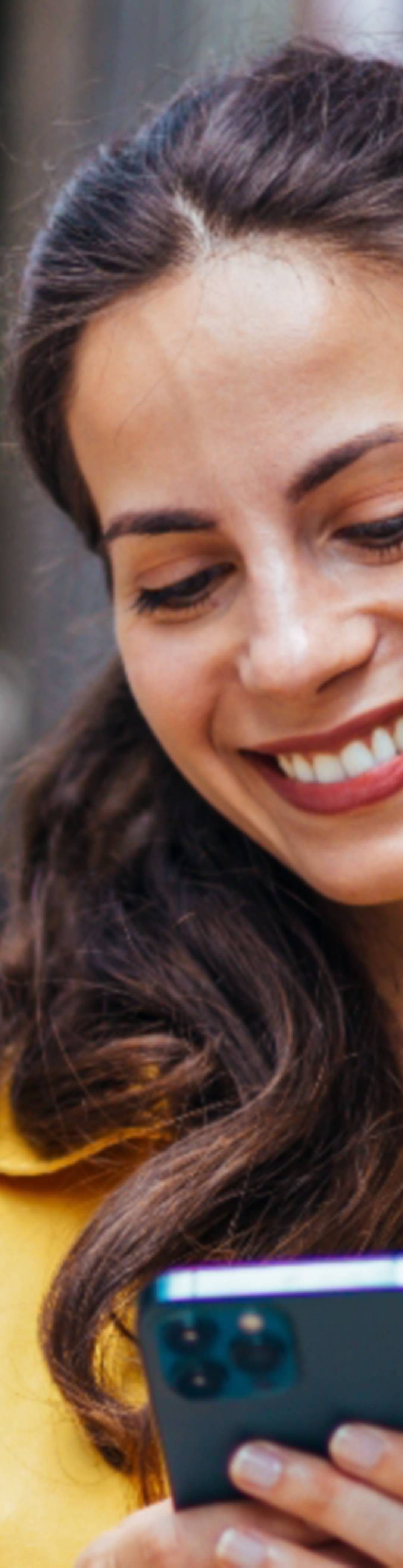 Dame smiler og ser på mobilen