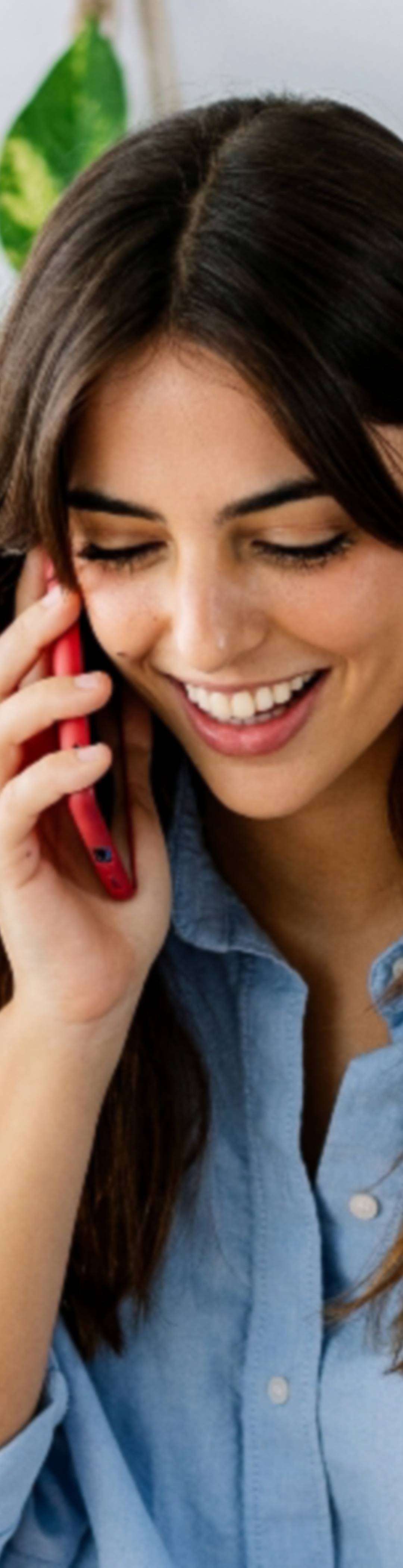 Kvinne snakker i telefon og smiler
