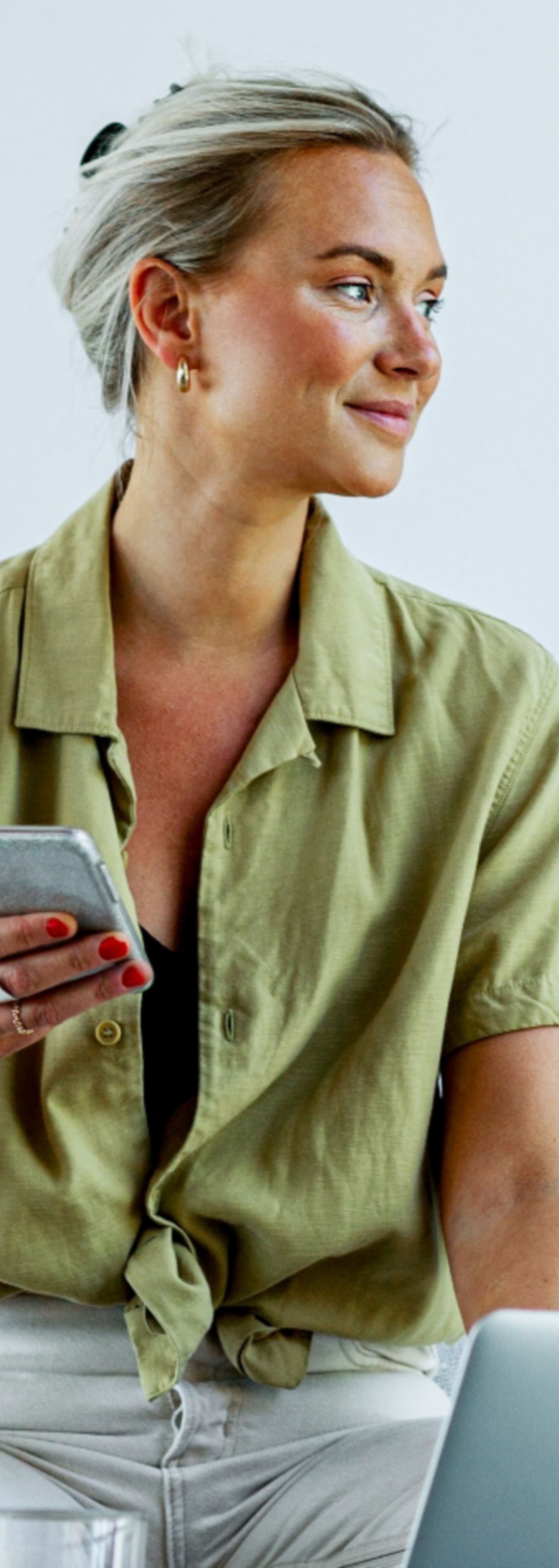 Kvinne med mobiltelefon skal velge forsikring når hun starter egen bedrift