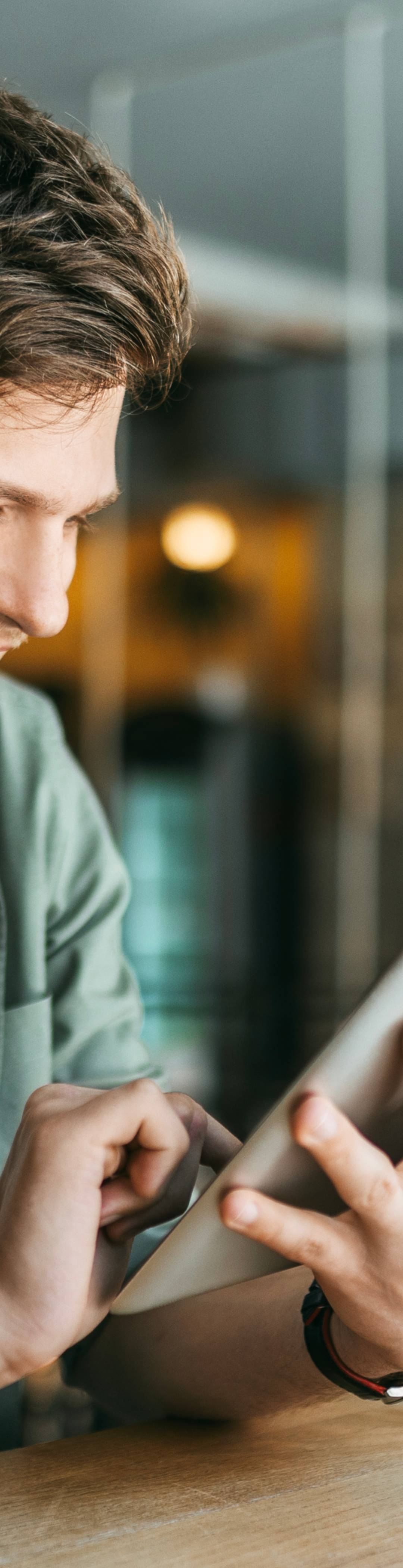 Mann med nettbrett på kaffebar