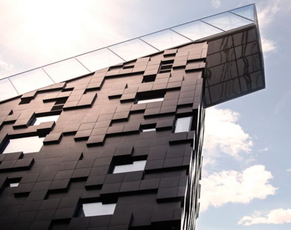 Image of a modern, black building with blue sky around it