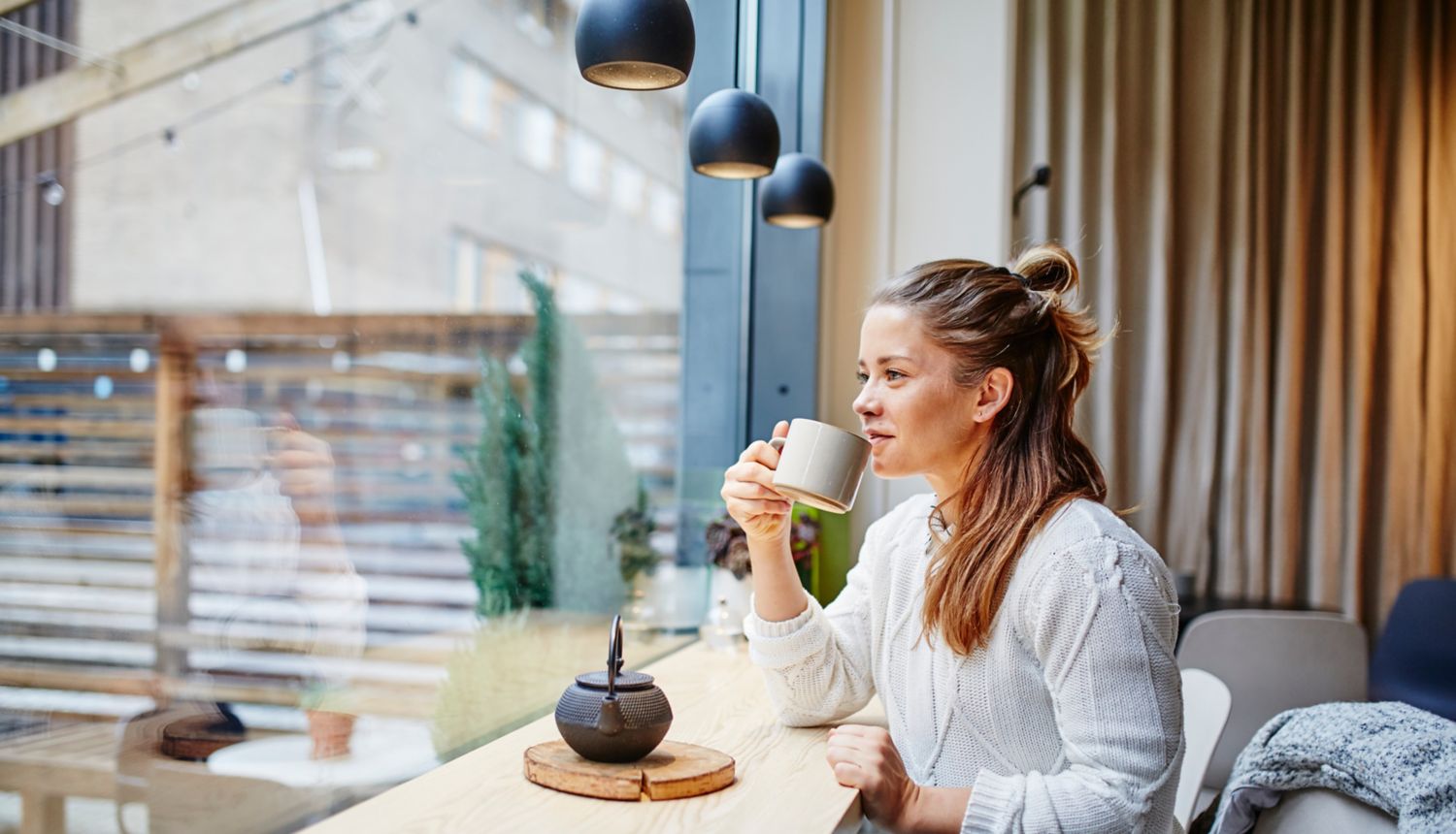 Ung kvinne drikker te på cafe PRISER